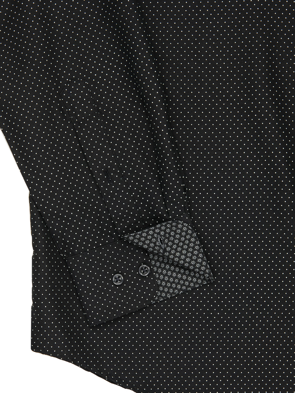 Close-up of a black patterned shirt with a button and cuff detail.