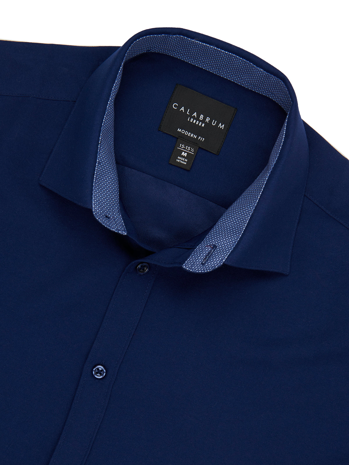 Close-up of a navy blue shirt with a Calabrum label on a white background
