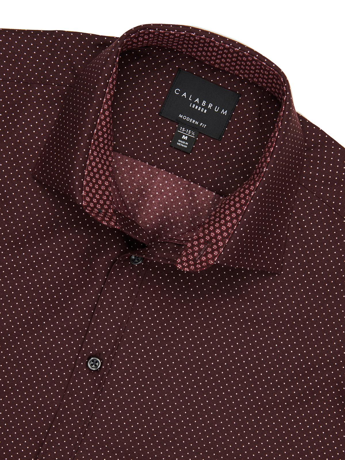 Close-up of a maroon patterned shirt with a Caldrum label on a white background