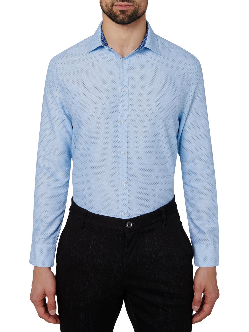 Man wearing a light blue dotted dress shirt and black pants on a white background