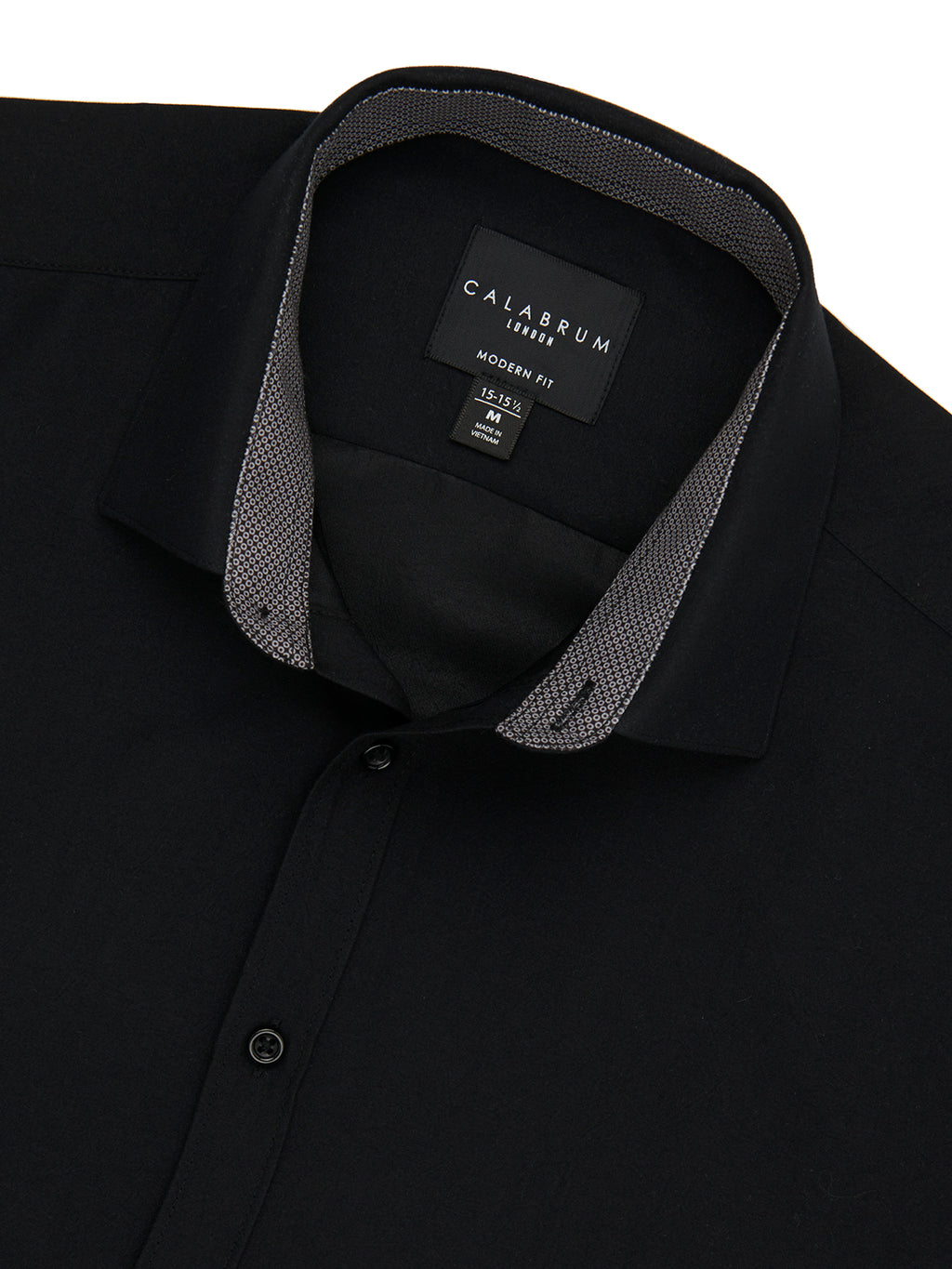 Close-up of a black shirt with a visible brand label on a white background
