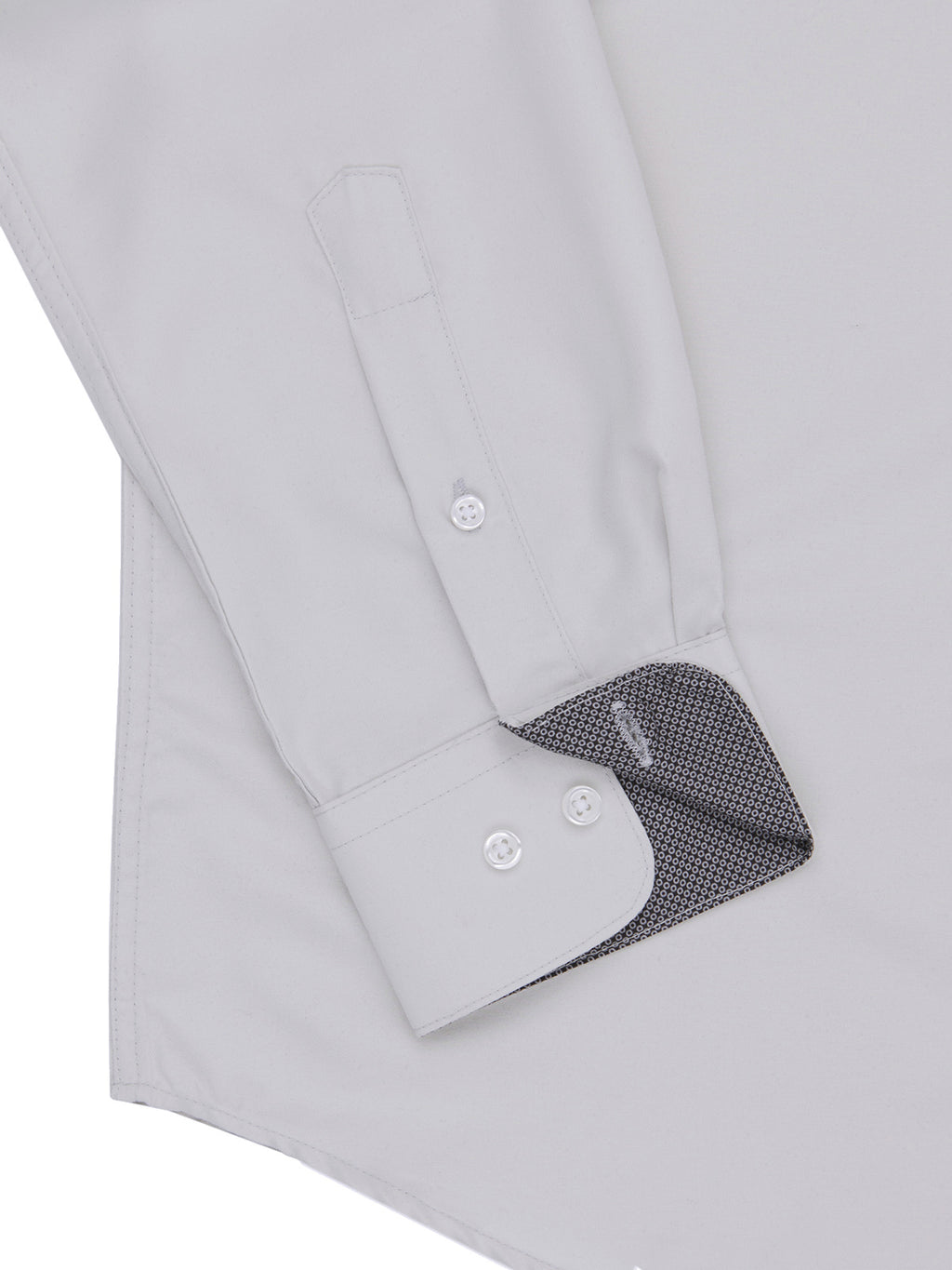 Close-up of a light gray dress shirt with rolled-up sleeve and black patterned lining.