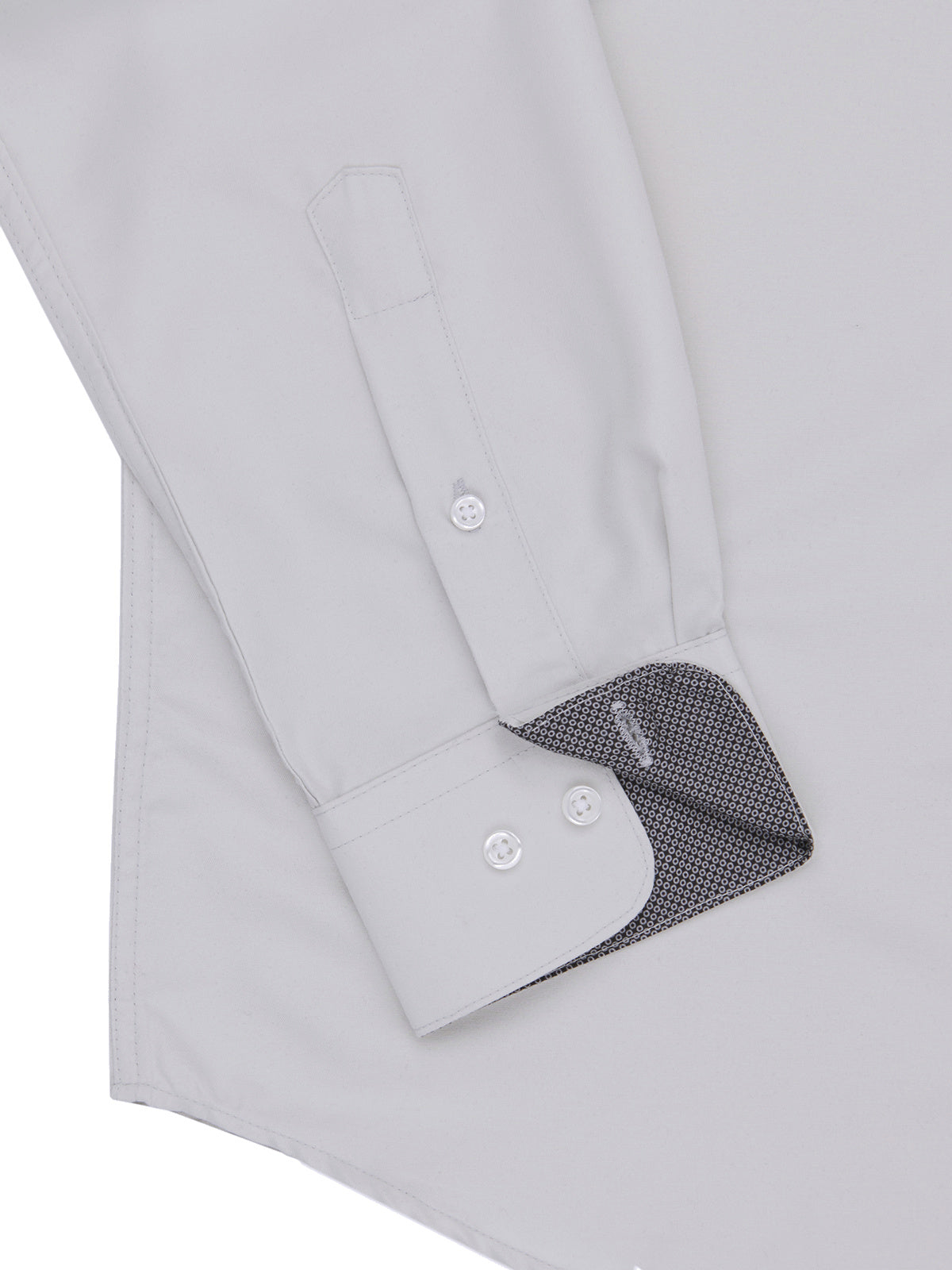 Close-up of a light gray dress shirt with rolled-up sleeve and black patterned lining.